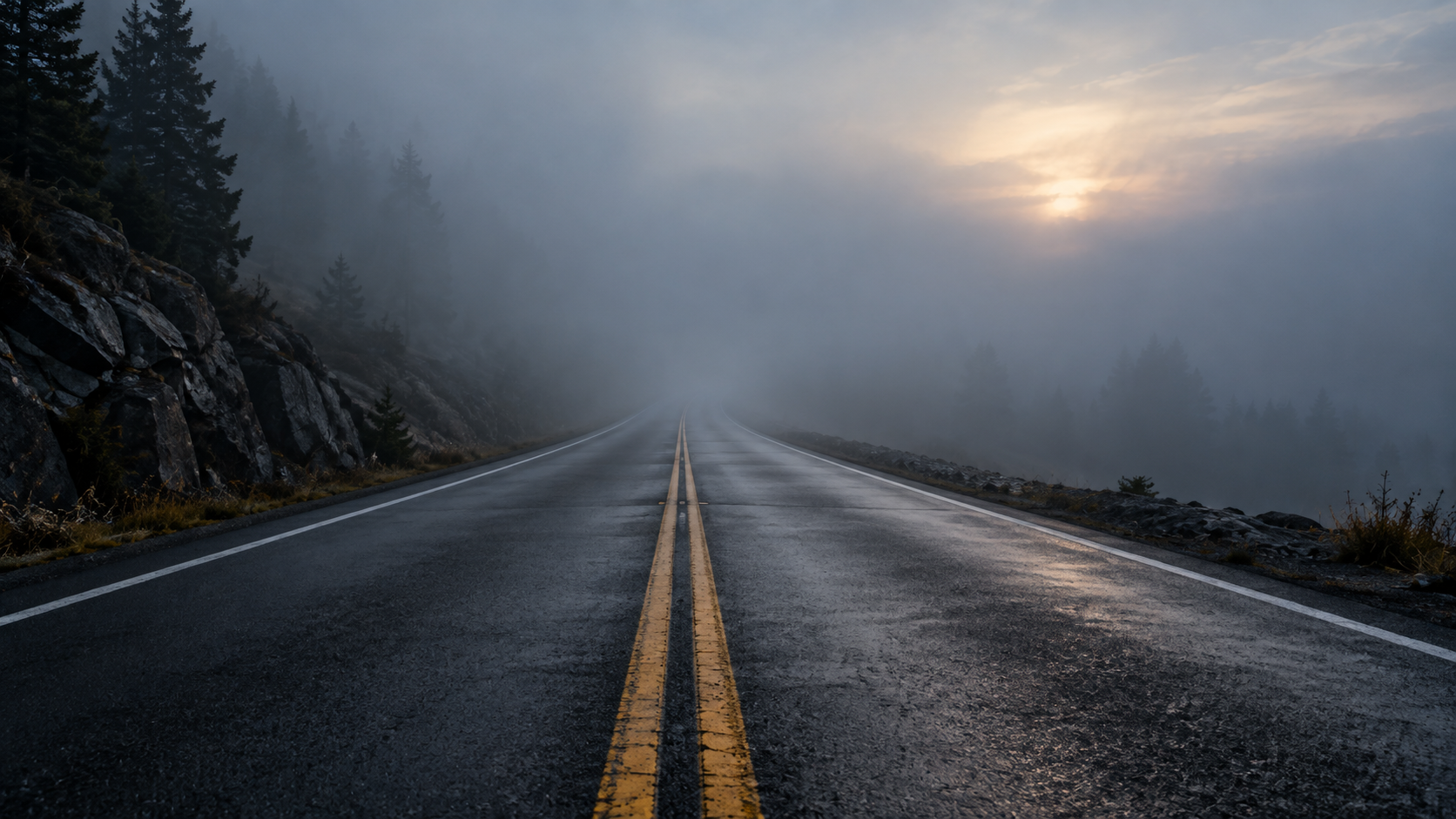 A road disappearing into dense fog at dusk